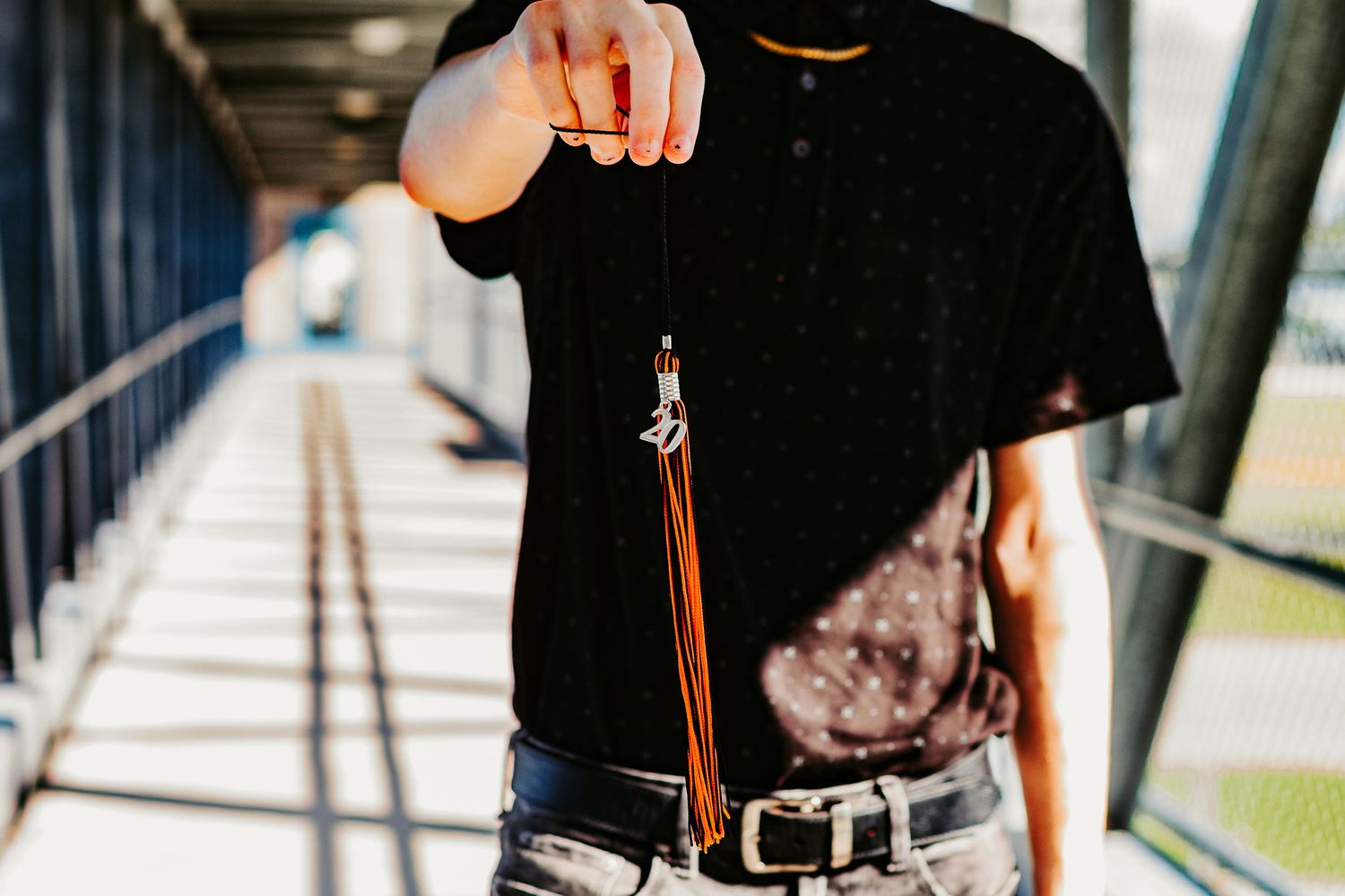 Close-up of hand holding keys against blurred hallway background.