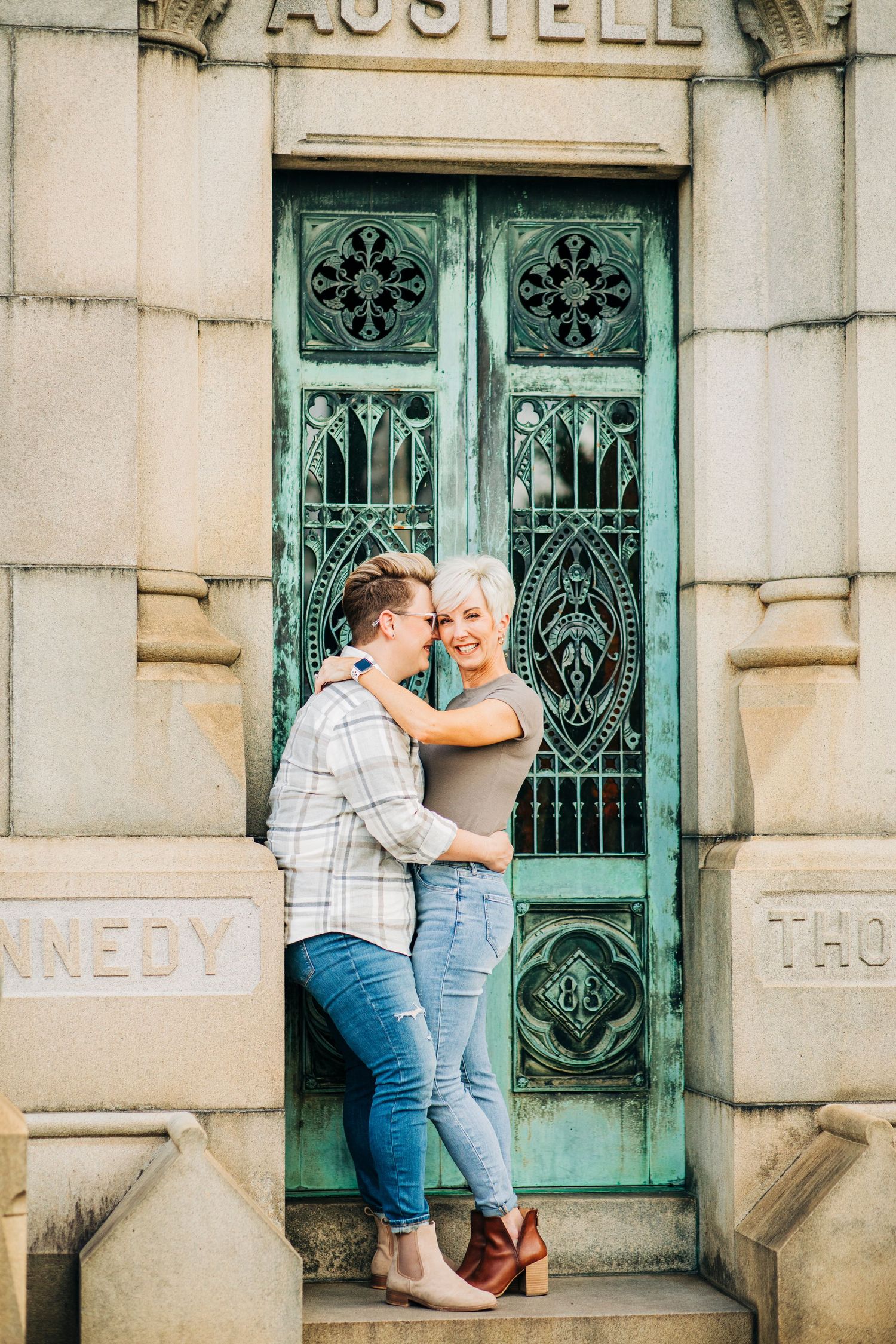 A couple poses romantically in front of an ornate vintage door marked 'Austell'.