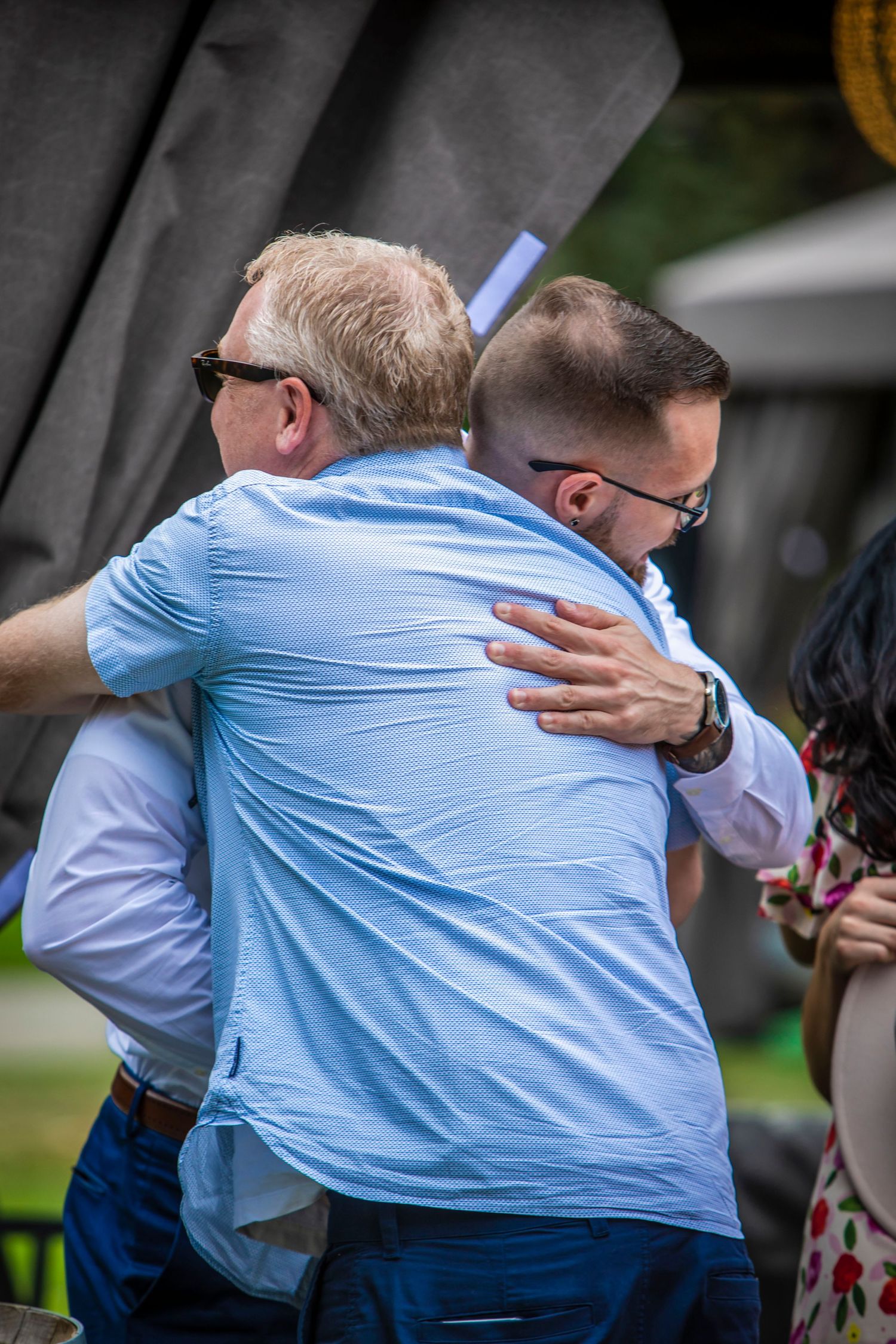 a dad hugging his son after a wedding proposal