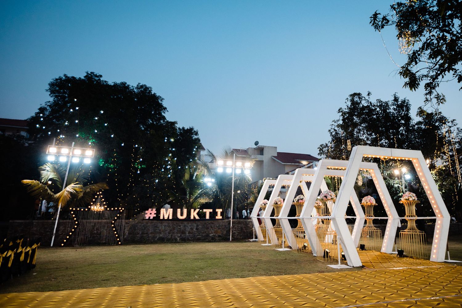 Large illuminated white letters create a dramatic outdoor wedding display at dusk.