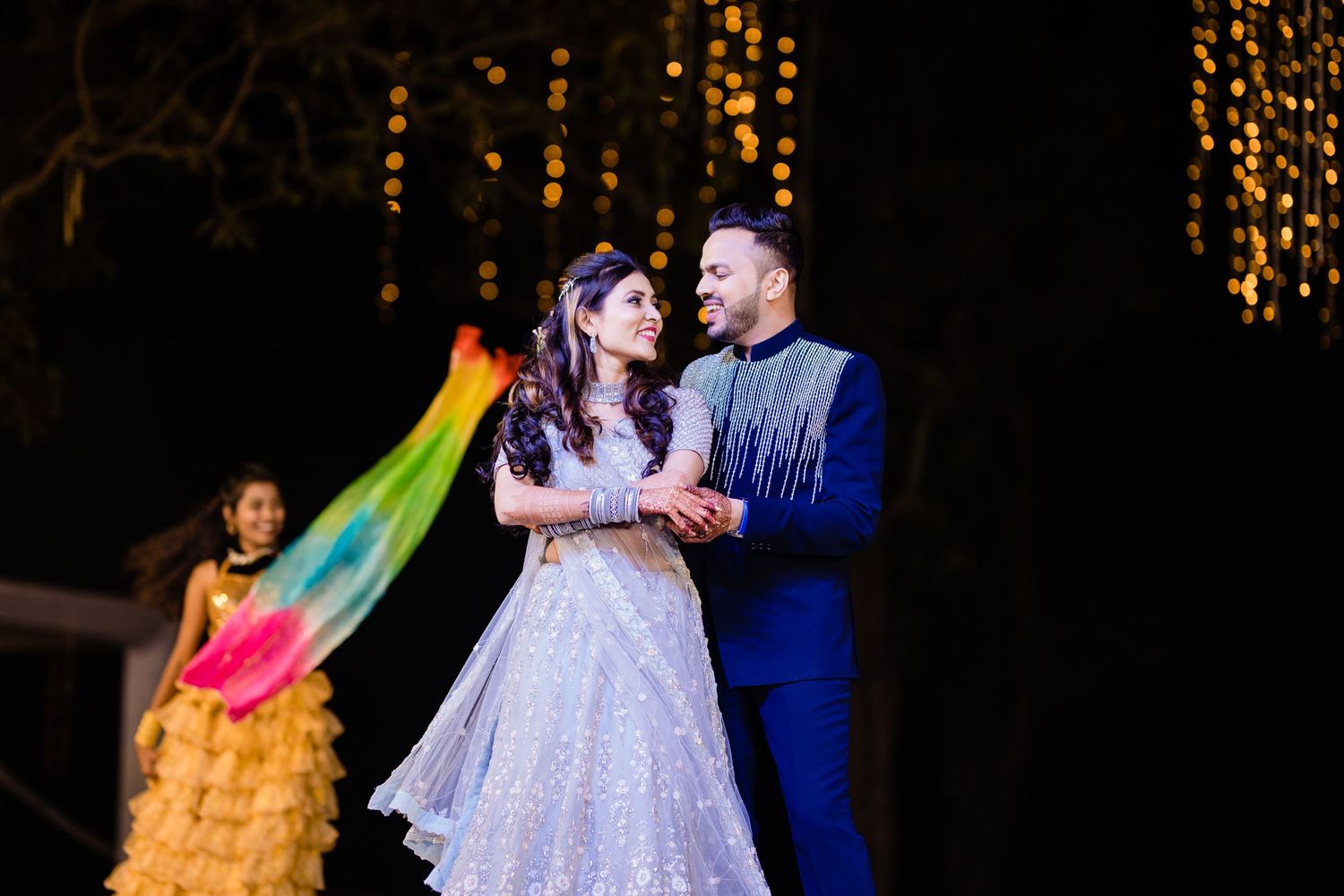 Couples perform a coordinated dance routine on stage with dramatic lighting effects.