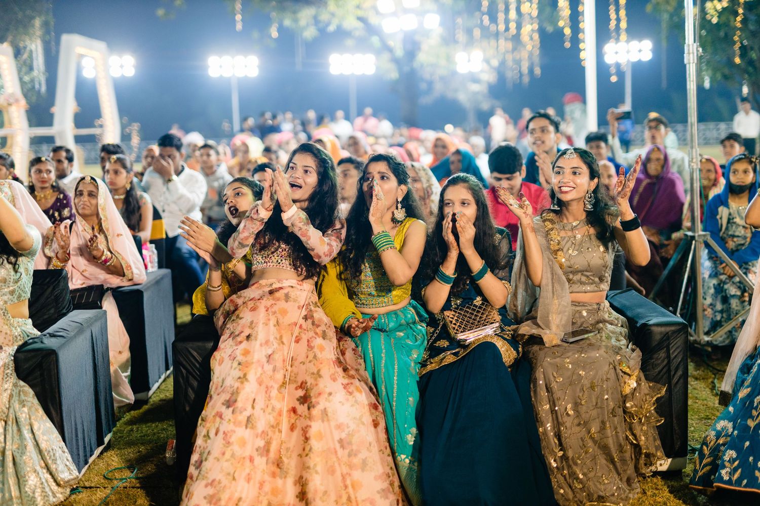 Wedding guests dance and celebrate during a lively reception with colorful traditional attire.