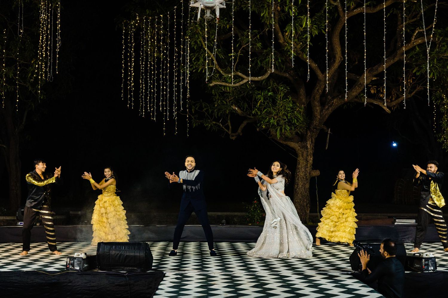 Dramatic stage performance with theatrical lighting and fog effects creating an atmospheric nighttime scene.