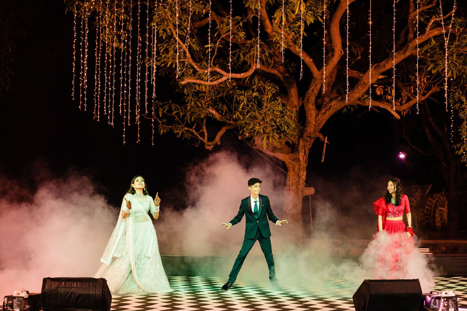 Stage performers in period costumes creating dramatic poses amidst theatrical smoke and lighting.