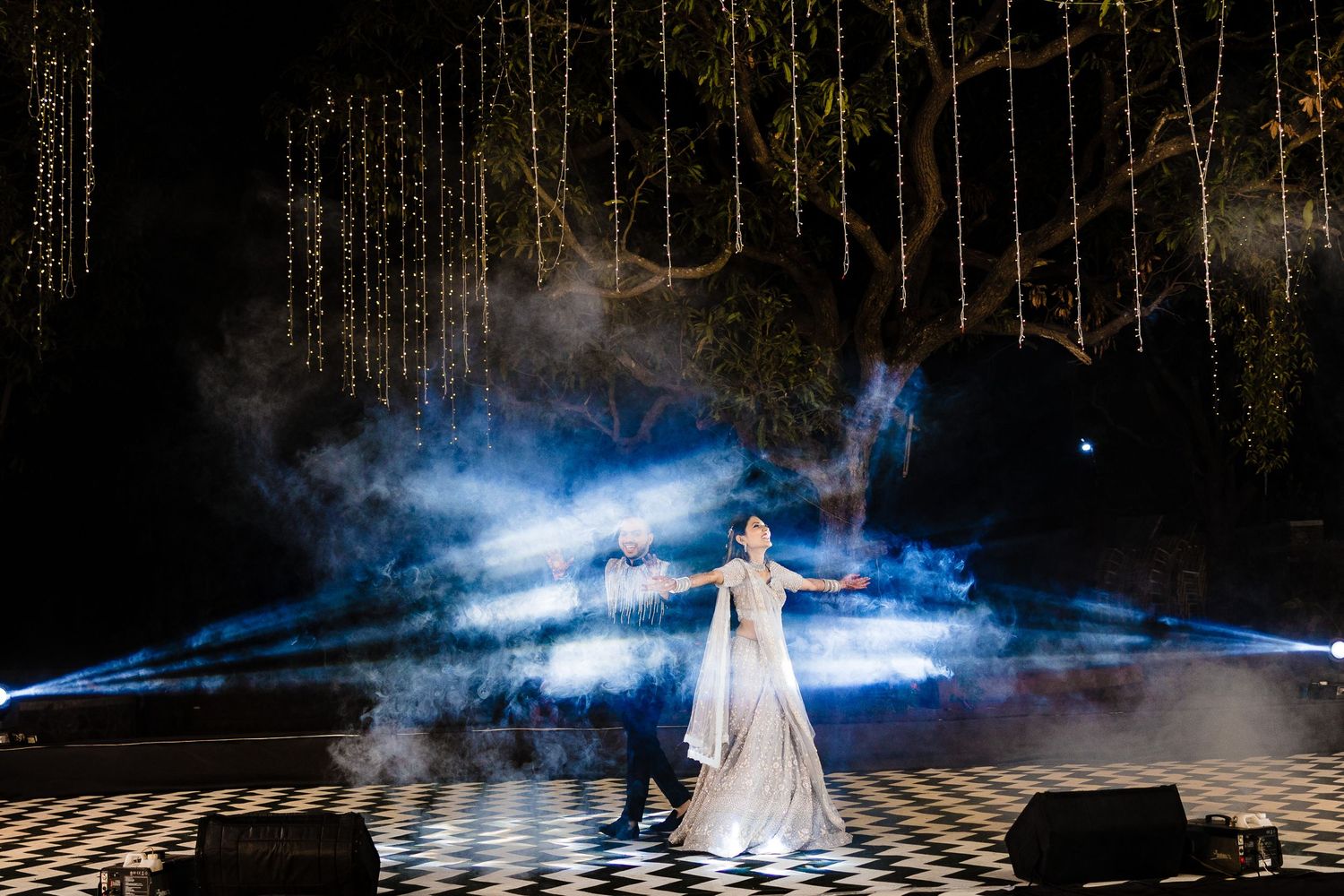 Dramatic stage scene with intense blue lighting and fog effects creating a mystical atmosphere.