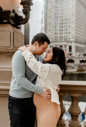 A tender embrace captured along Chicago's historic river walk with architectural details.