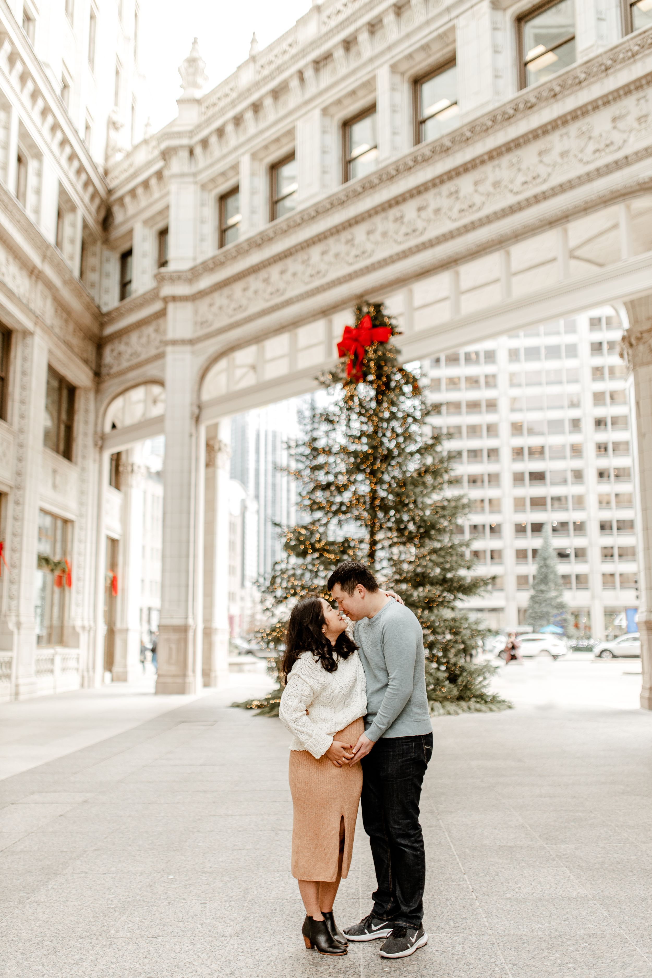 A romantic moment captured in front of a decorated Christmas tree in downtown Chicago.