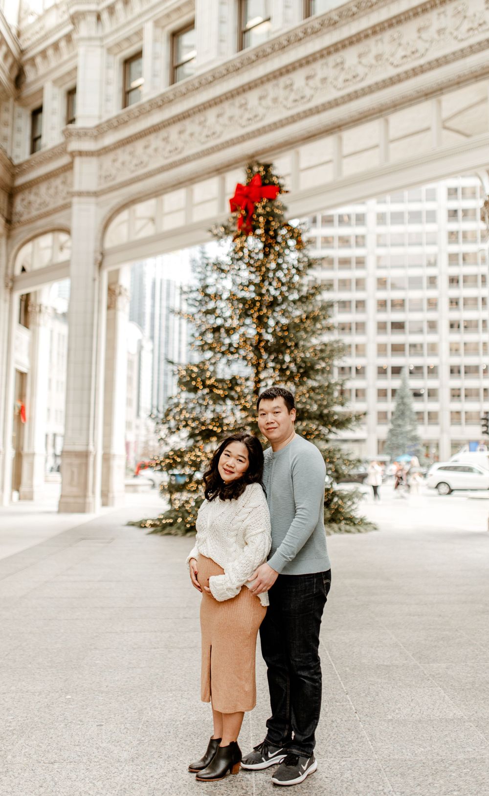 A holiday portrait featuring a decorated Christmas tree and classic Chicago building facade.