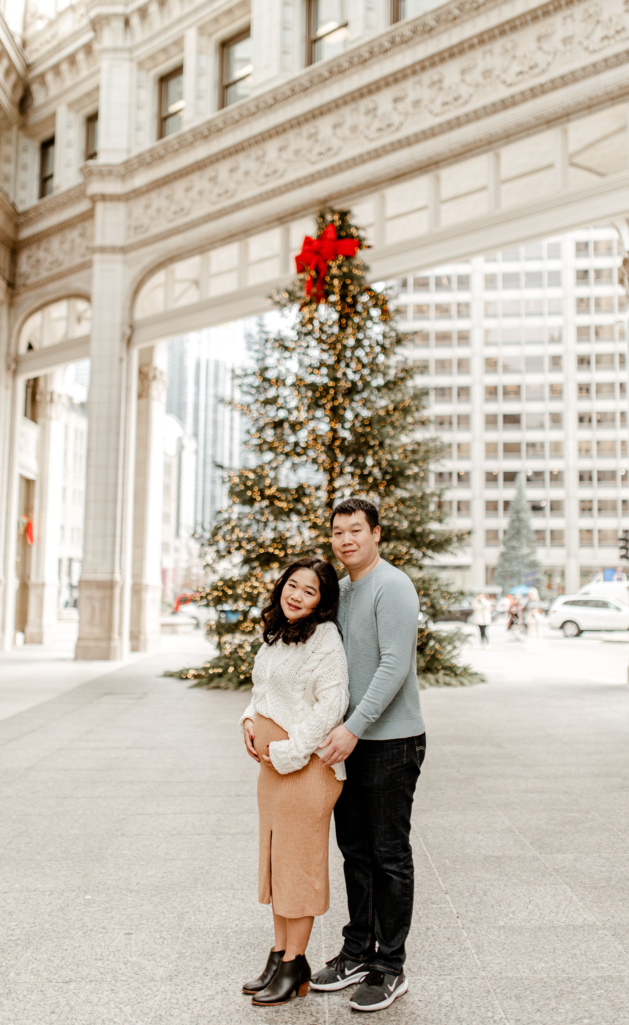 A holiday portrait featuring a decorated Christmas tree and classic Chicago building facade.