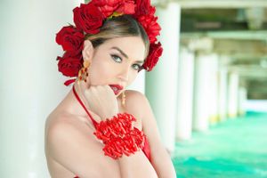 Close-up portrait showcasing red floral accessories and classic makeup.