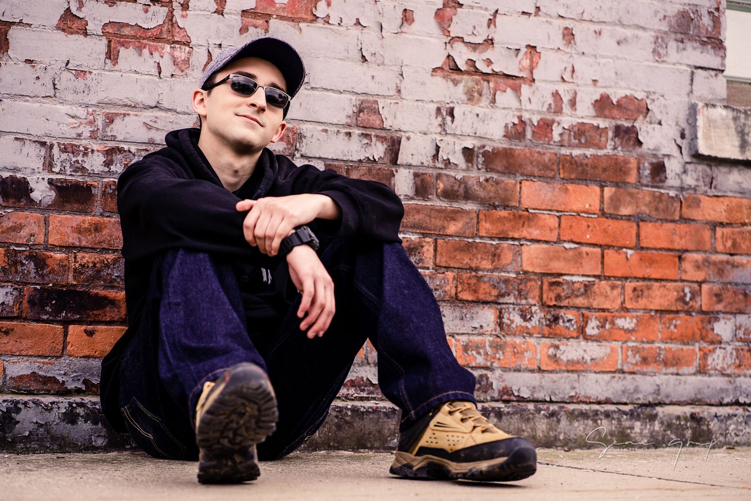 Casual portraits against weathered brick wall in urban setting.