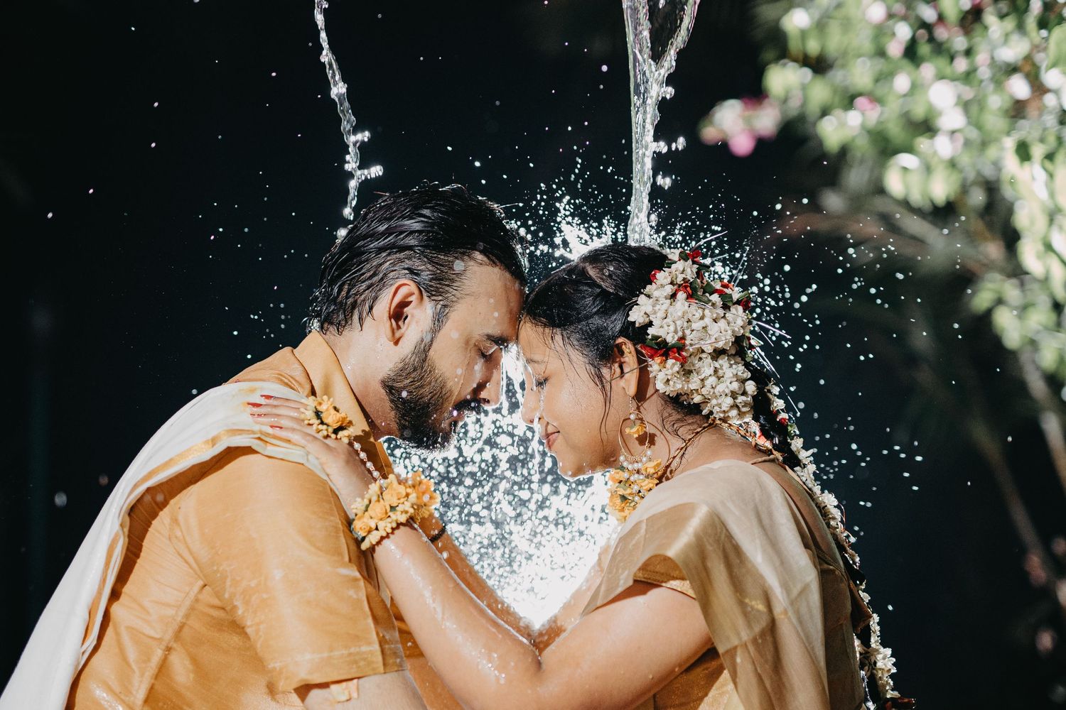 Artistic water splash photography against natural foliage background.
