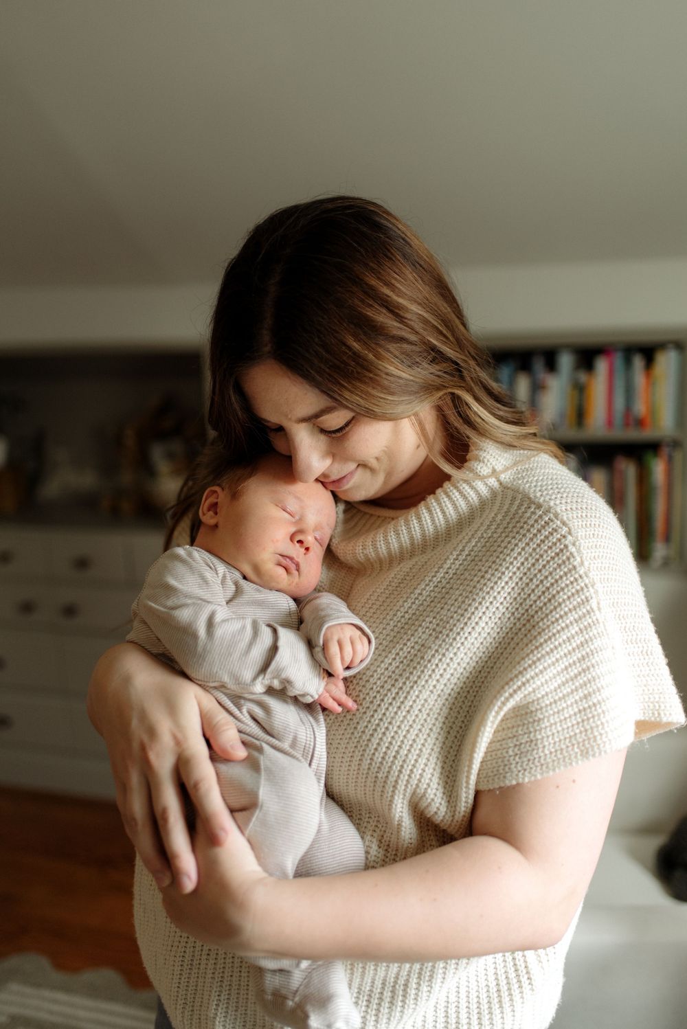 Intimate bonding moment between parent and baby in a cozy white sweater.