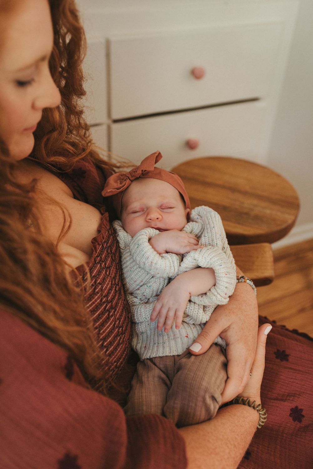 A tender moment with a sleeping infant wrapped in a knit sweater.