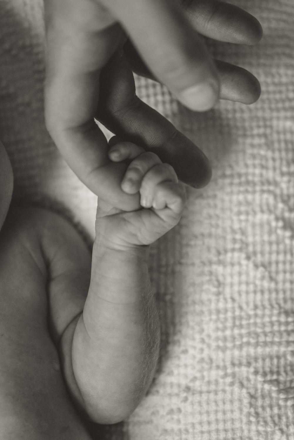 Series of close-up black and white images showing gentle touches and massages on a baby's foot.