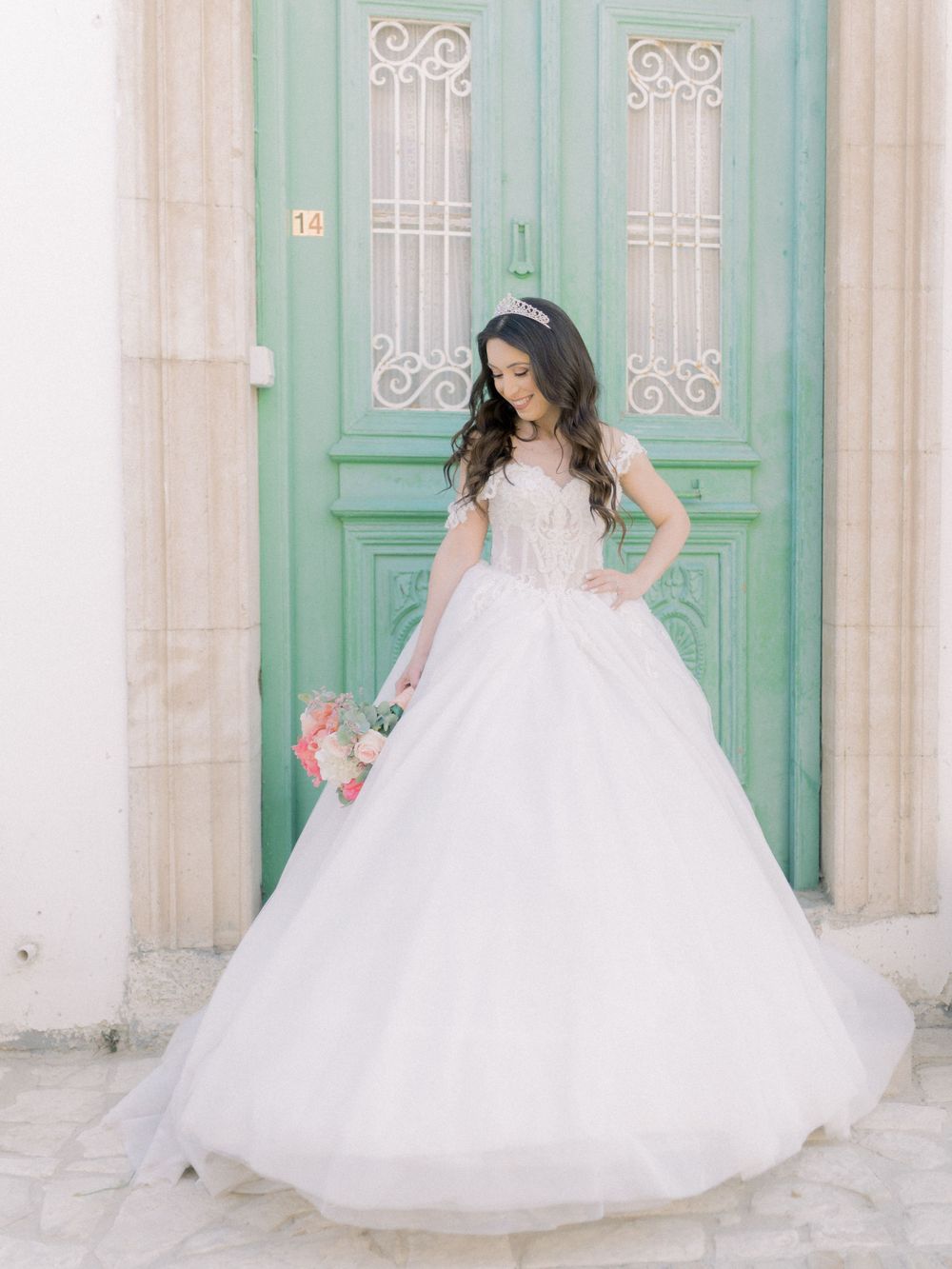 Destination wedding in Cyprus, Lefkara village. Bride in a stunning bridal dress standing in front of a door