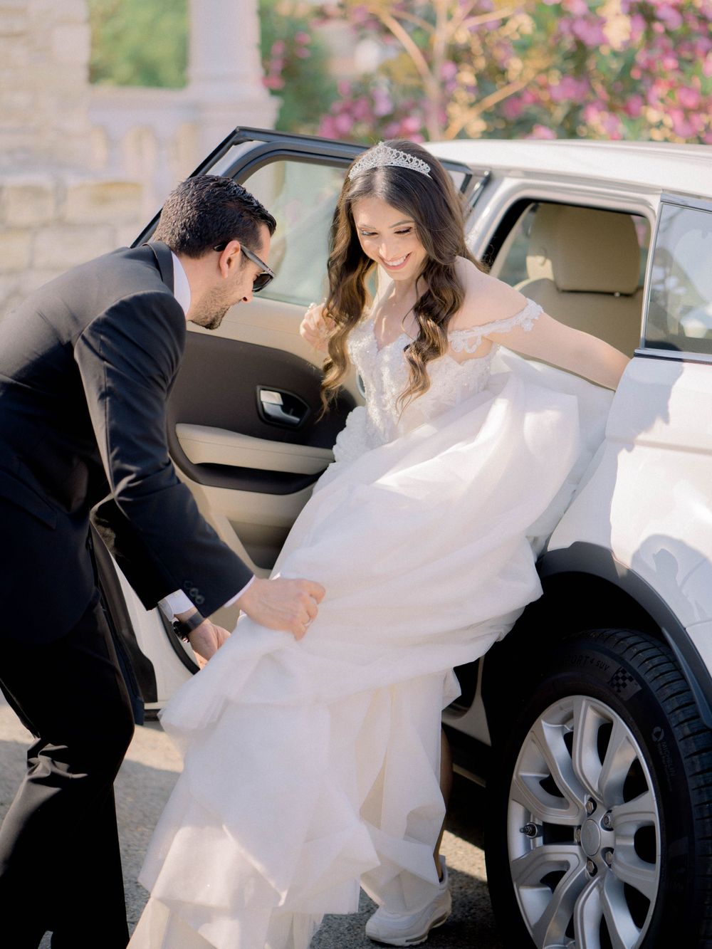 Destination wedding in Cyprus, Lefkara village. Groom helps the bride to get down of the car