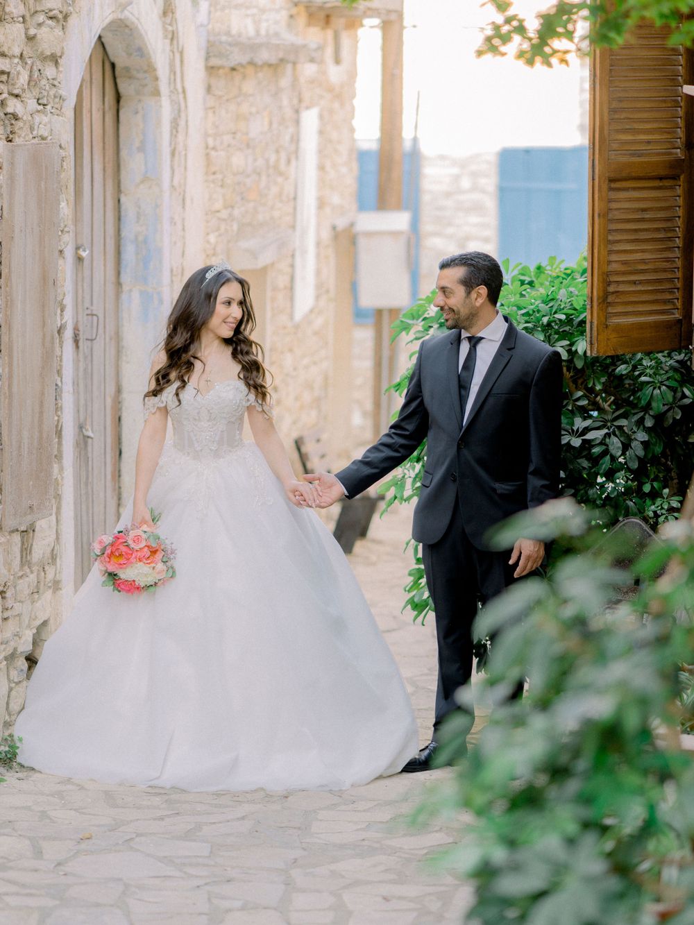 Bride and Groom standing next to each other holding hands and looking each other in Lefkara village