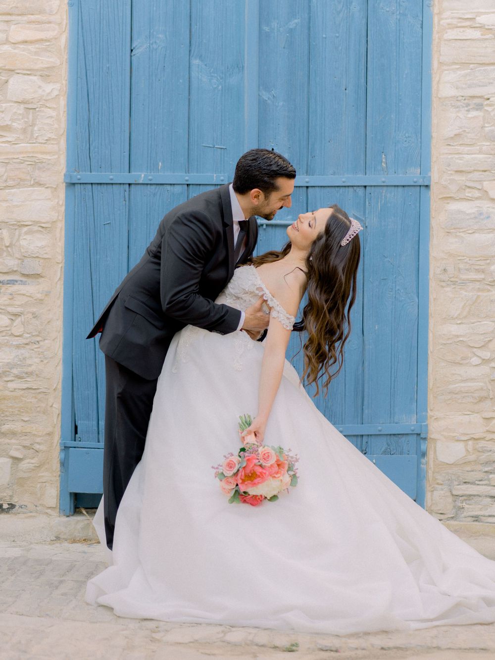 Groom leans Bride backwards reaching to give her a kiss
