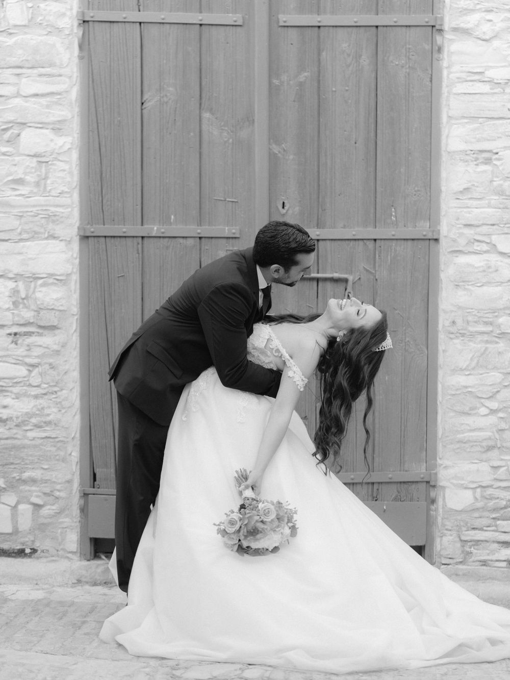 Groom leaning bride backwards in black and white