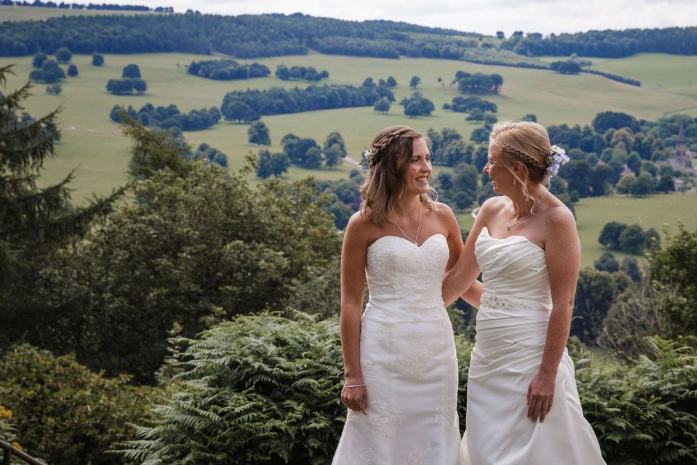 Rolling countryside views provide a scenic backdrop for wedding portraits on a grassy hilltop.