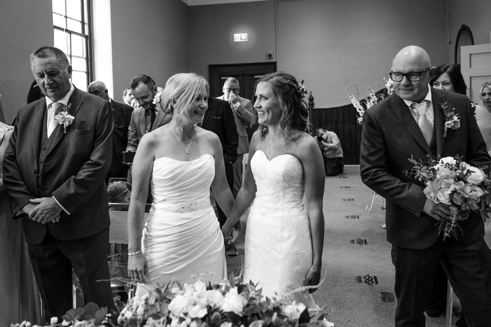 Black and white candid moments captured during an indoor wedding ceremony.