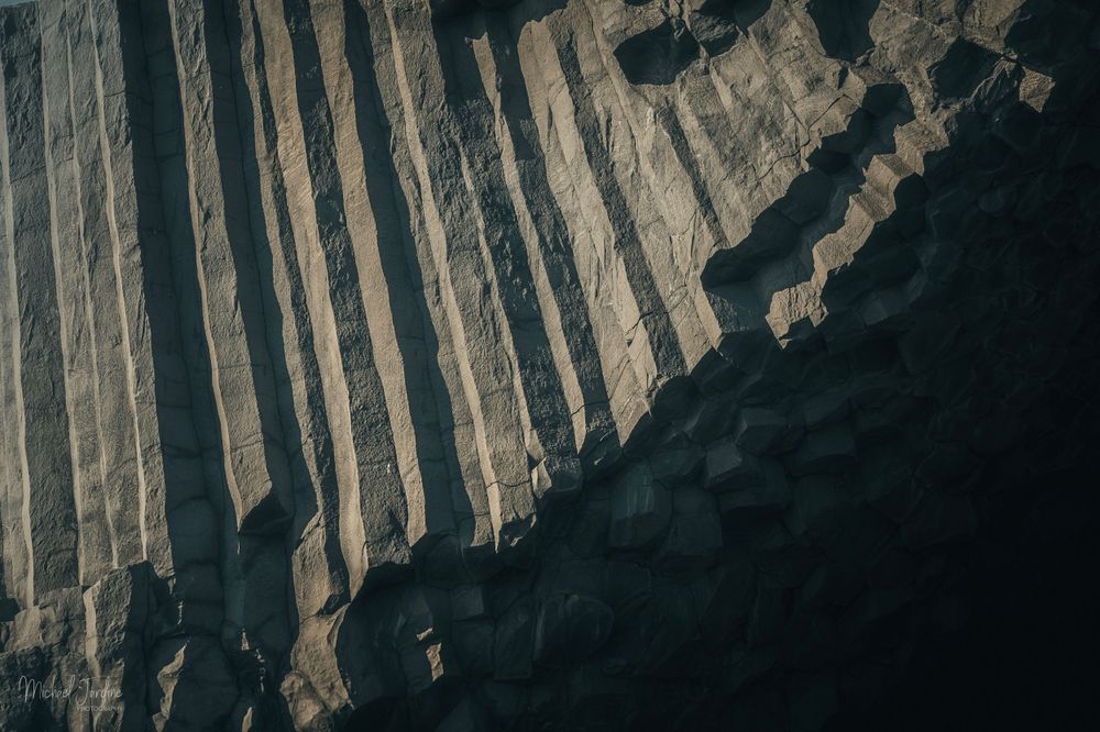 Dramatic angular rock formations creating geometric patterns in dark lighting.