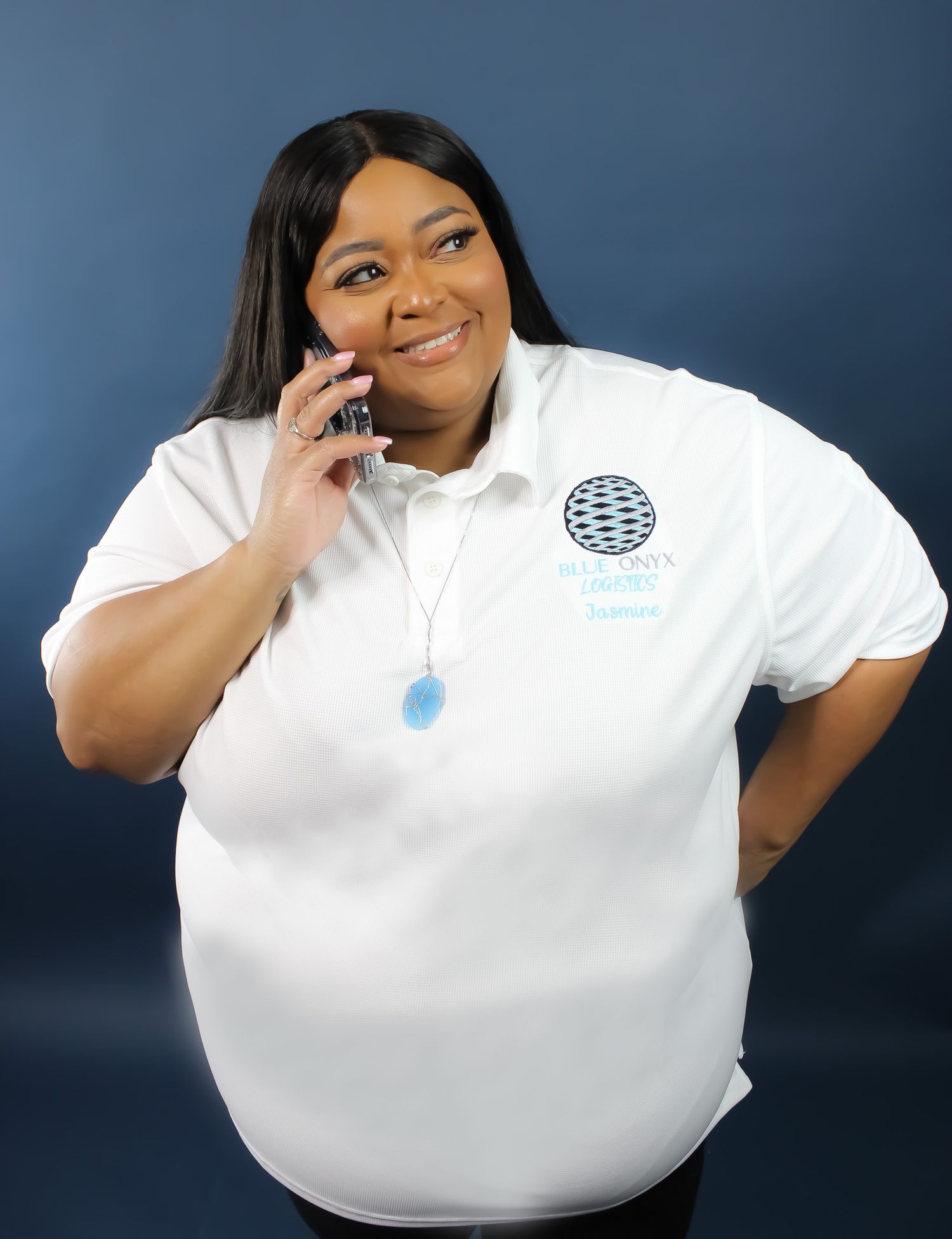 A person wearing a white polo shirt with a logo poses against a blue background.