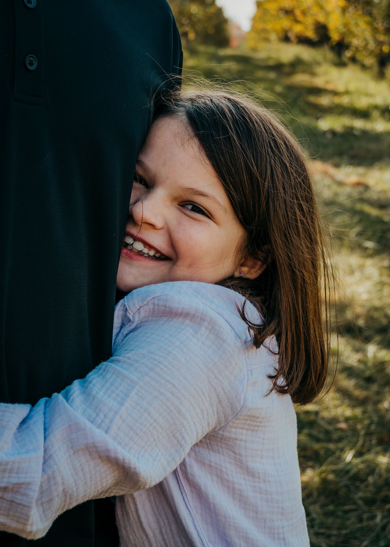 sister gives big brother a hug during family portraits