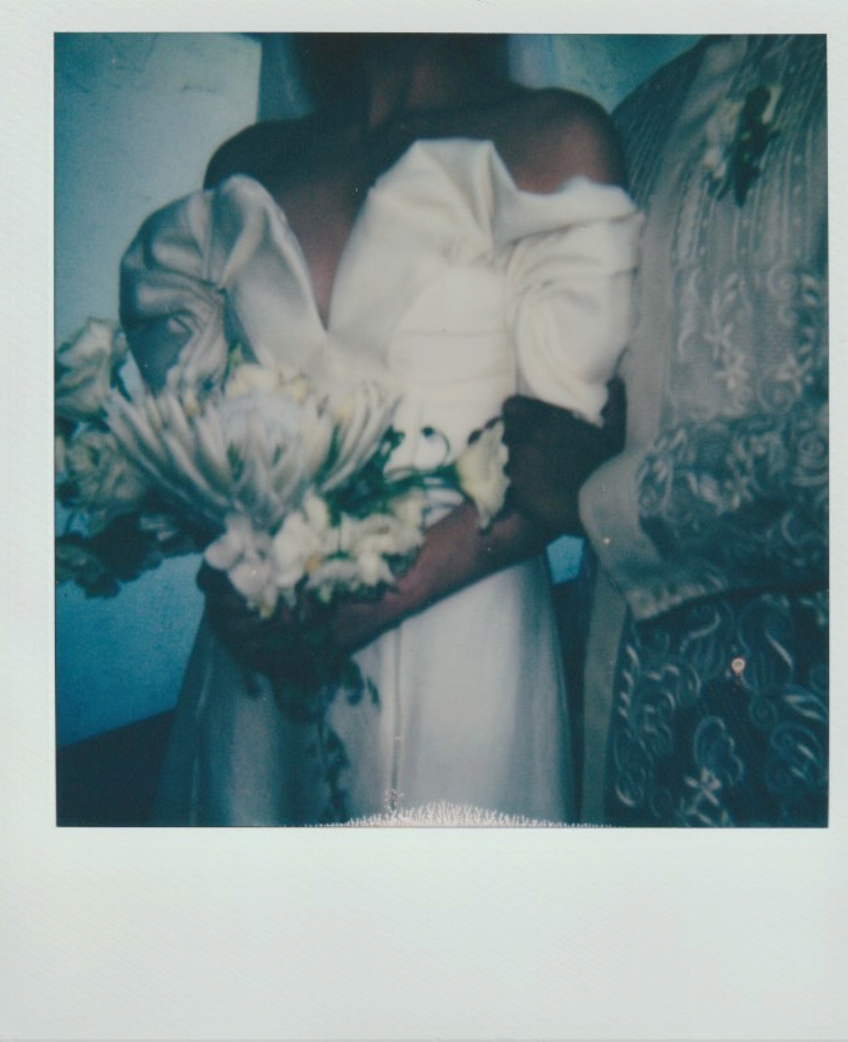 Artistic polaroid showing white wedding dress and floral bouquet with teal tint effect.