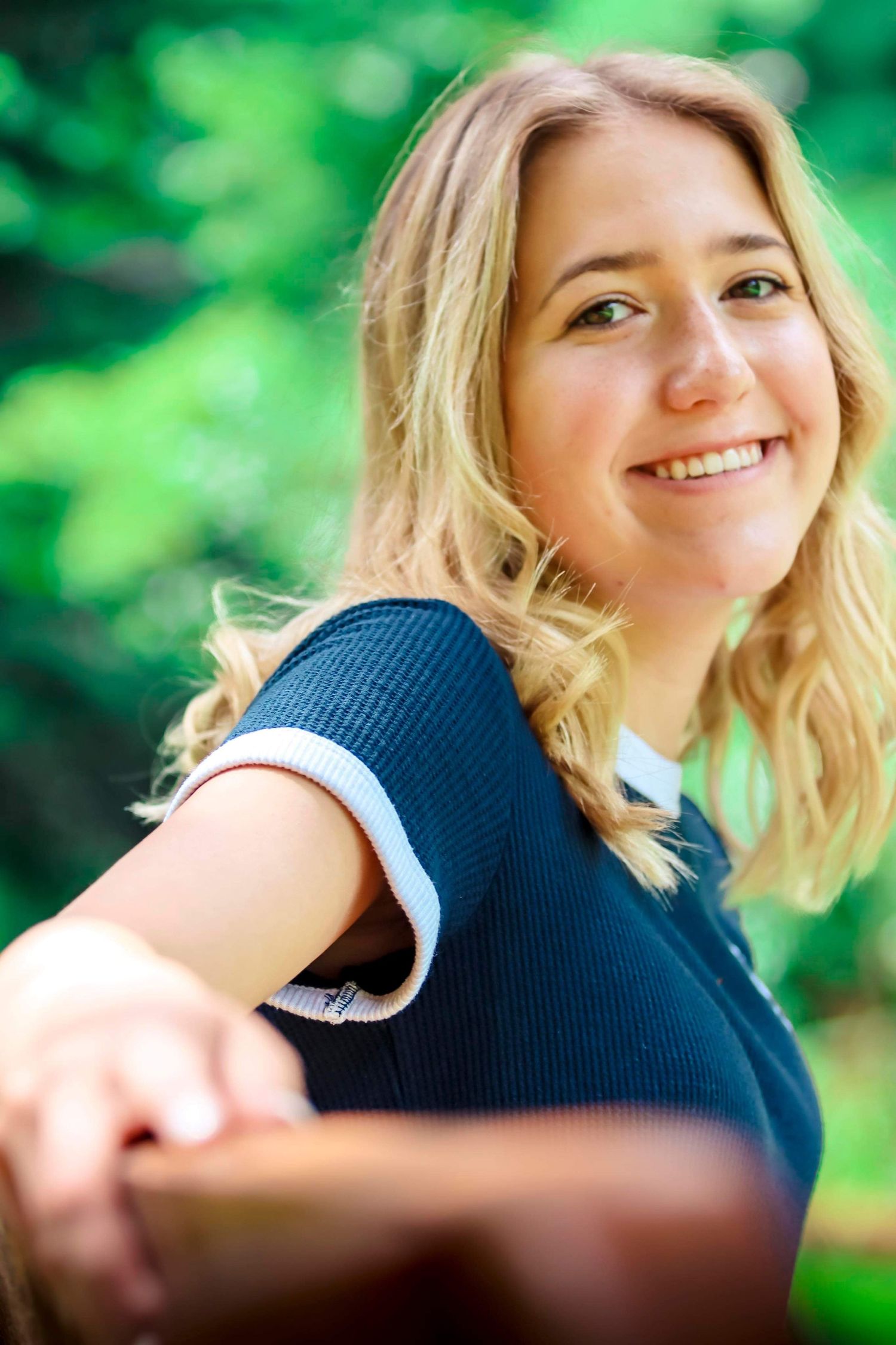 Portrait with soft natural lighting and green bokeh background.