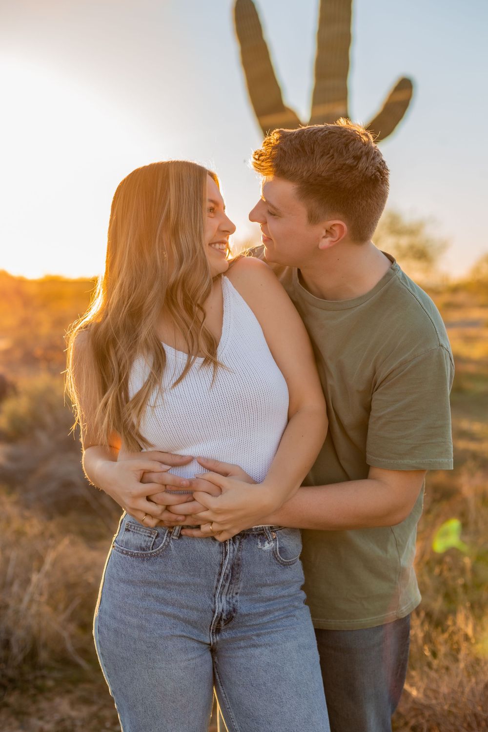 A tender desert photoshoot at golden hour with saguaro cactus in background.