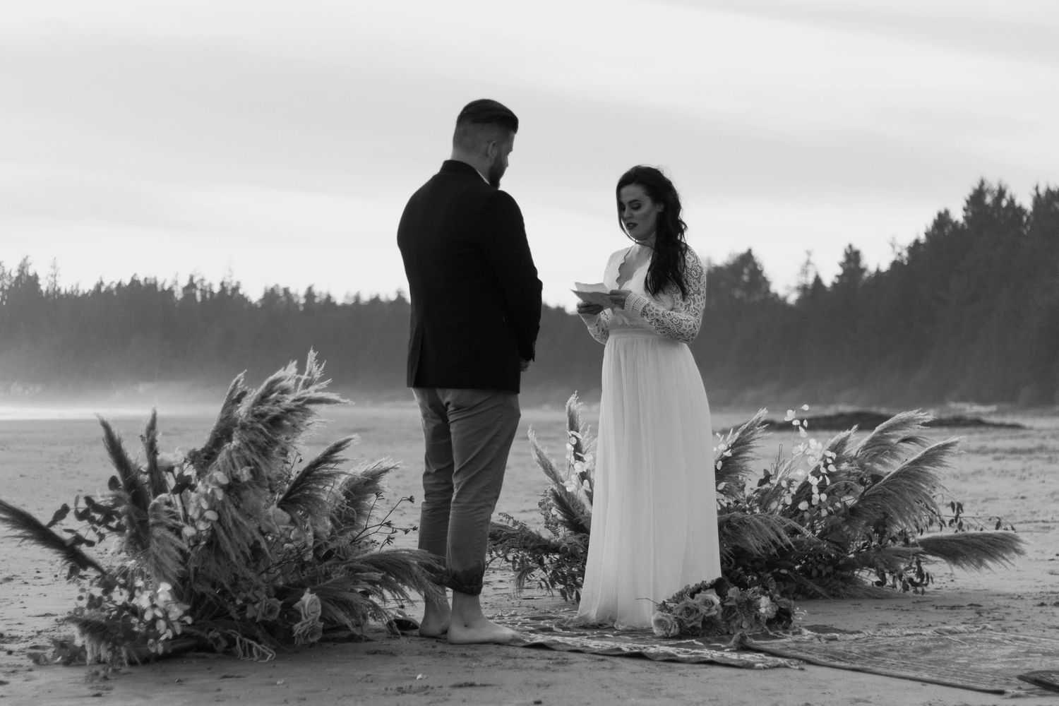 Bride reading her vows to groom while standing on the beach during their Tofino, British Columbia Beach Elopement