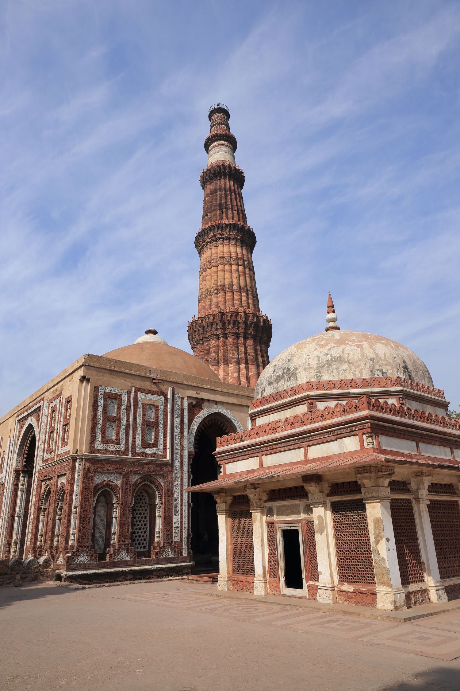 Historic Qutub Minar complex with ornate dome and architectural details in New Delhi.