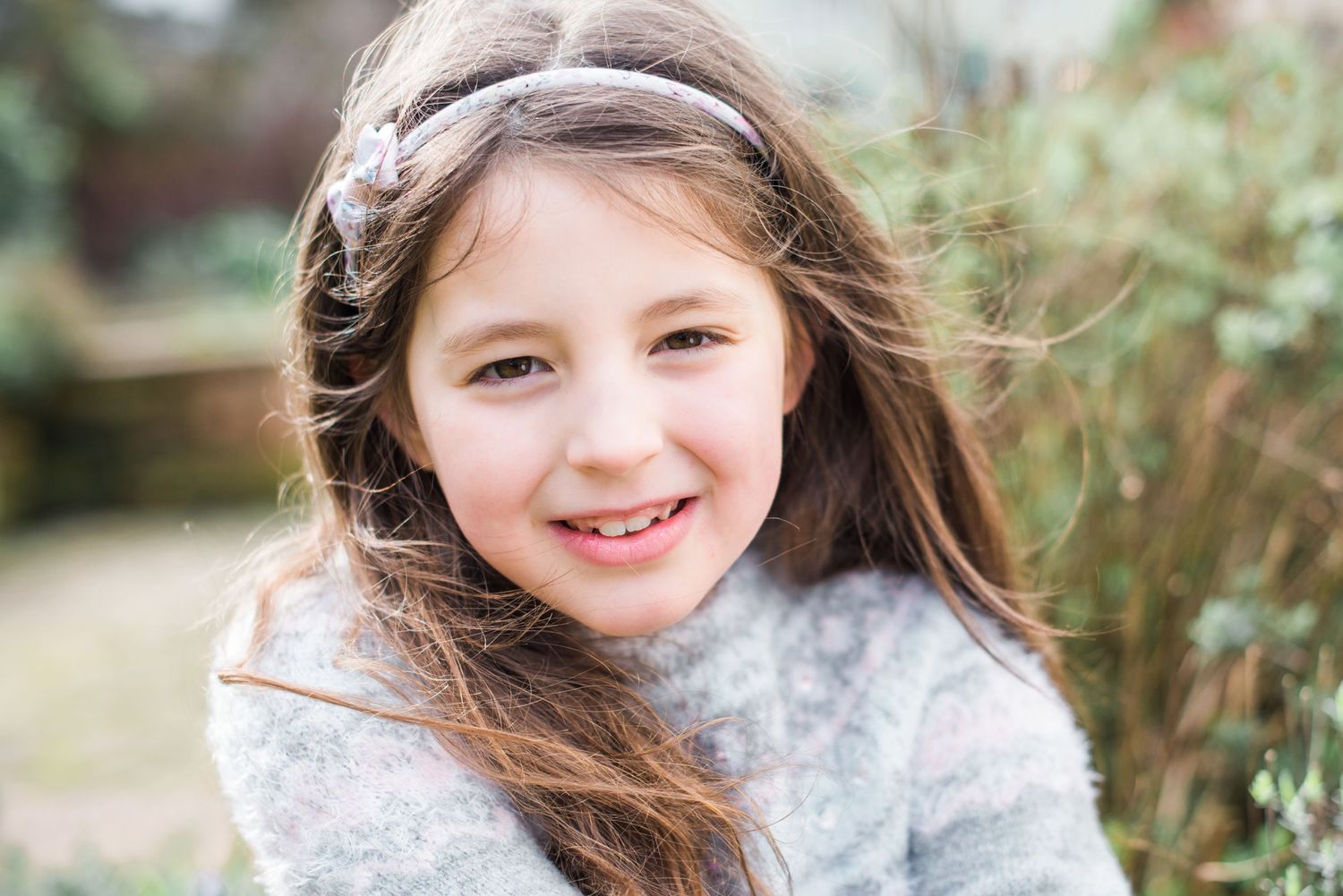 A little girl is relaxed and smiling at the camera during a Lake District portrait shoot.