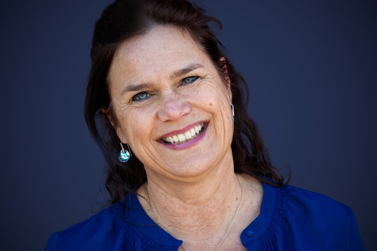 Zakelijk portret lachende vrouw tegen blauwe achtergrond, Barbara Kempeneers Fotografie, Personal Branding Fotografie