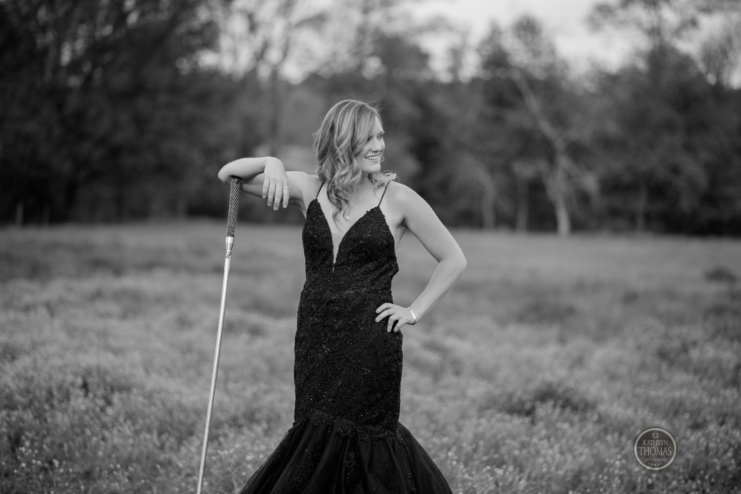 A black and white portrait showcasing a mermaid-style formal dress in an outdoor setting.