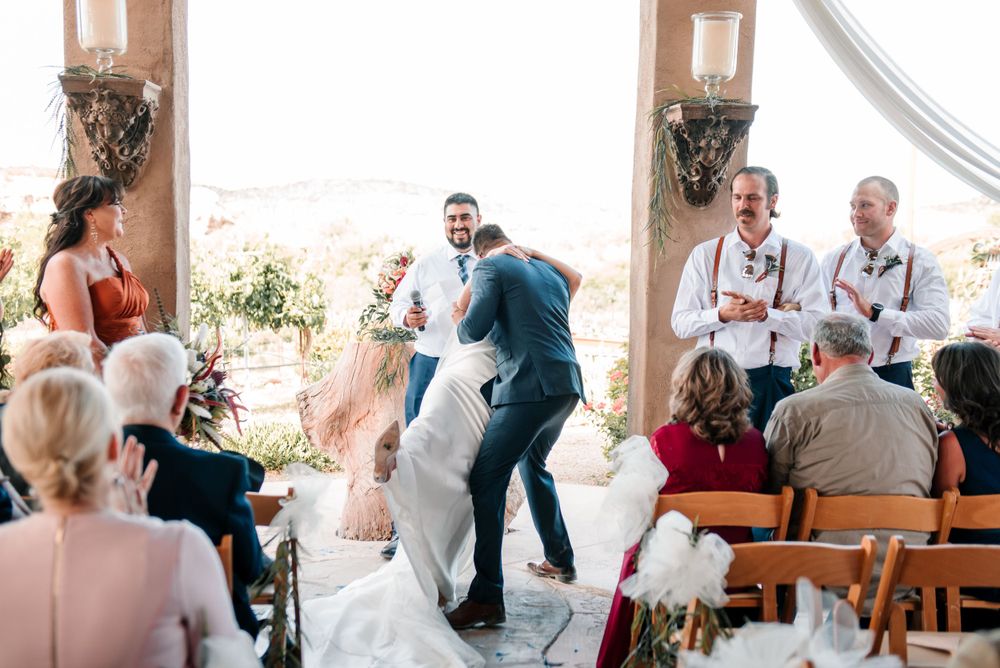 Wedding guests dancing and celebrating during a joyful outdoor ceremony.