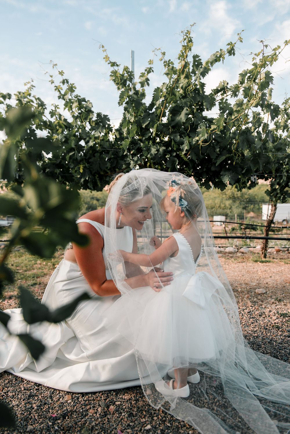 Sweet moment between two people in wedding attire sharing an intimate moment in a vineyard.