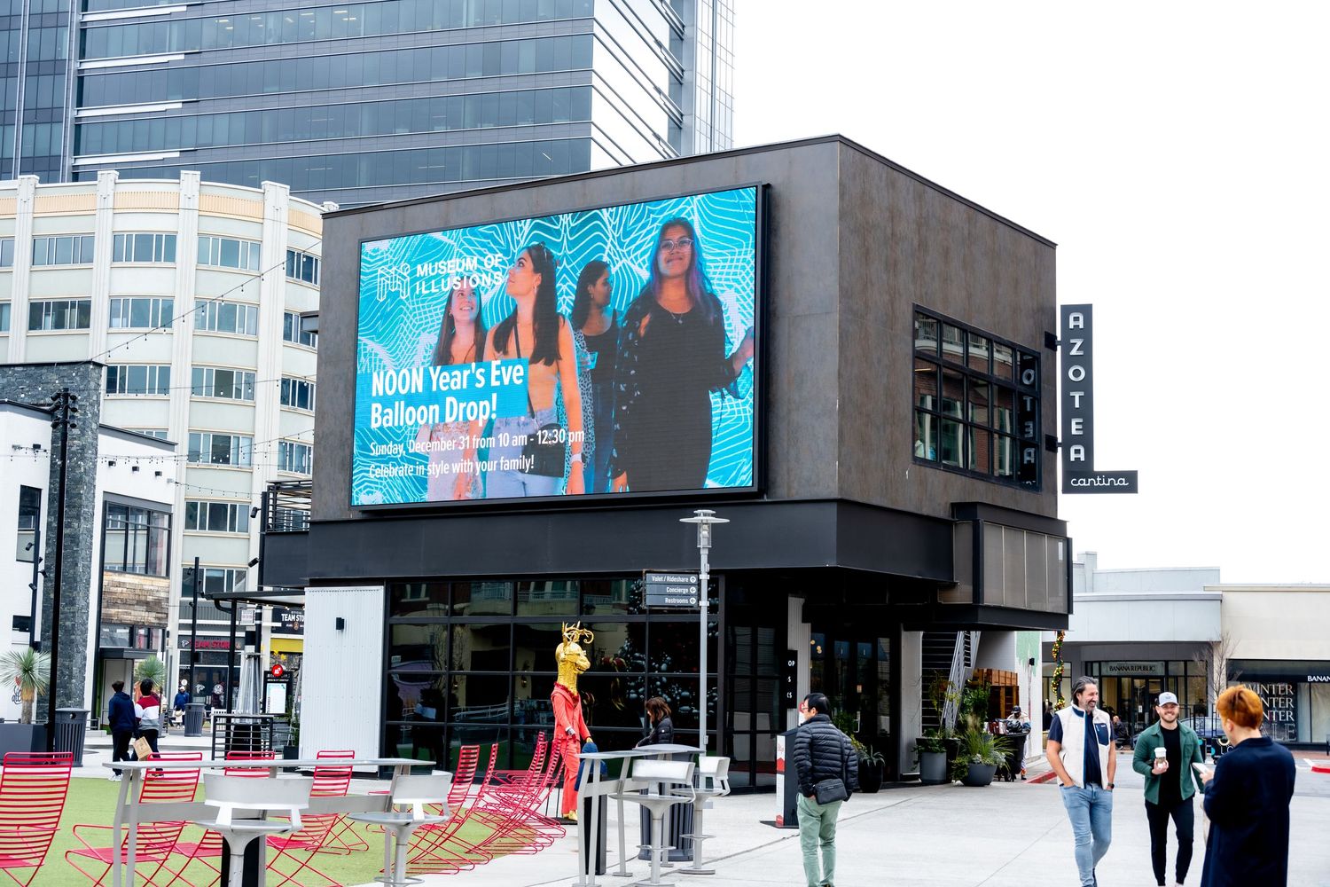 Commercial building with electronic display screen in busy city intersection.