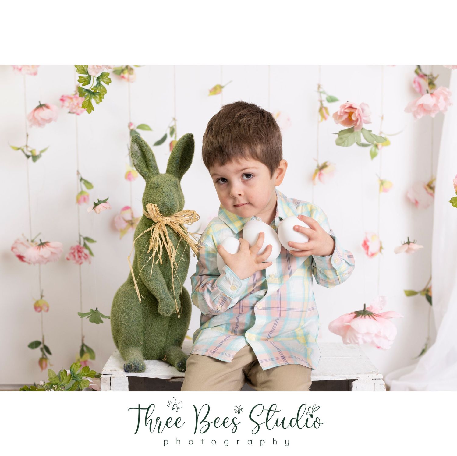 Easter themed photo with plush bunny and floral backdrop in soft spring colors.