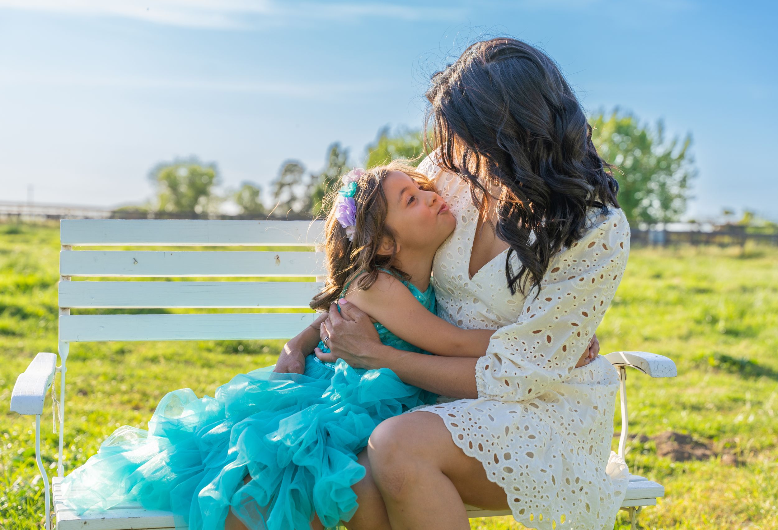 Young girl expressing her love and affection, sweetly kissing her mom during a heartwarming photoshoot