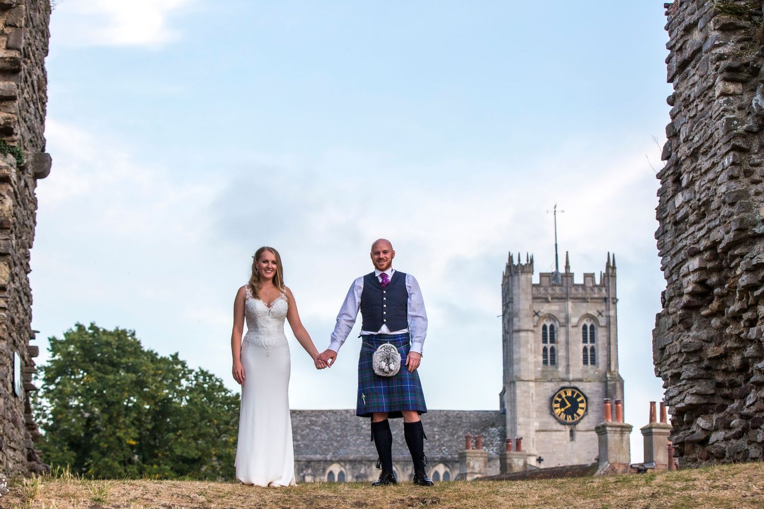 A scenic wedding photo with historic cathedral spires visible in the background.