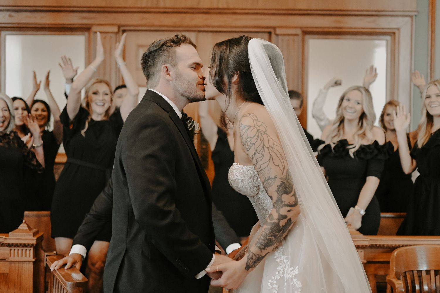 Wedding guests watching ceremony in a formal courtroom setting.