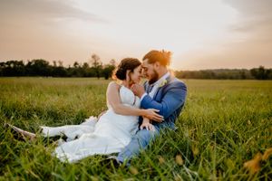 Bride and groom snuggling in the tall grass at the Manor House at Bohemia Overlook in Chesapeake, MD.