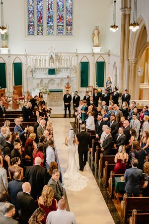 Father walking his daughter, the bride down the aisle of St. Thomas the Apostle Catholic church in Wilmington, Delaware.