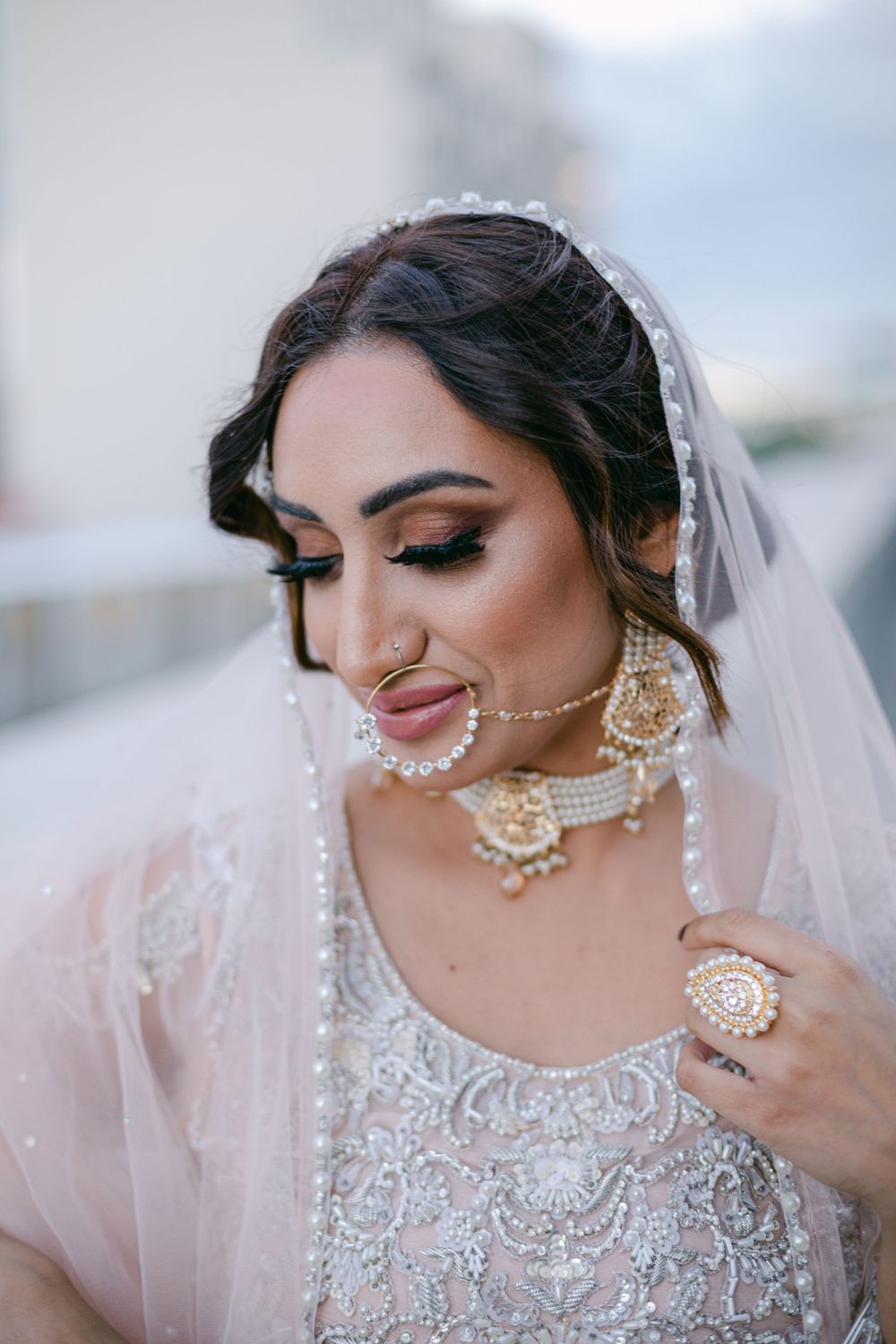 Close-up bridal portrait featuring traditional jewelry and detailed embroidered outfit.