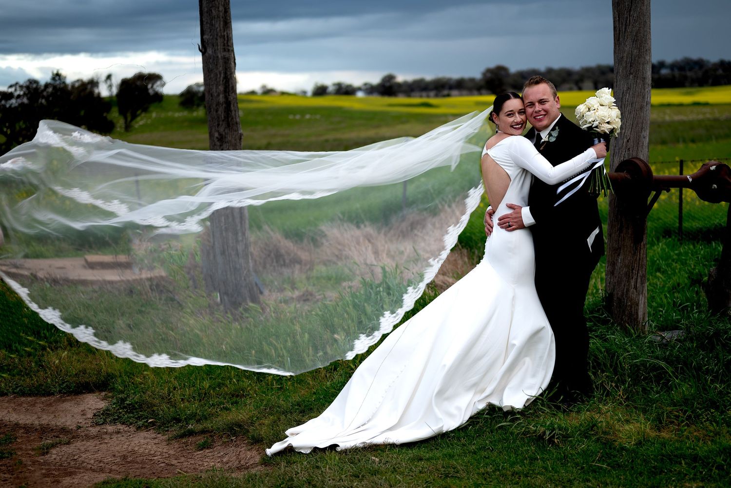 Bride and Groom hugging in front of canola crop Dubbo Photographer