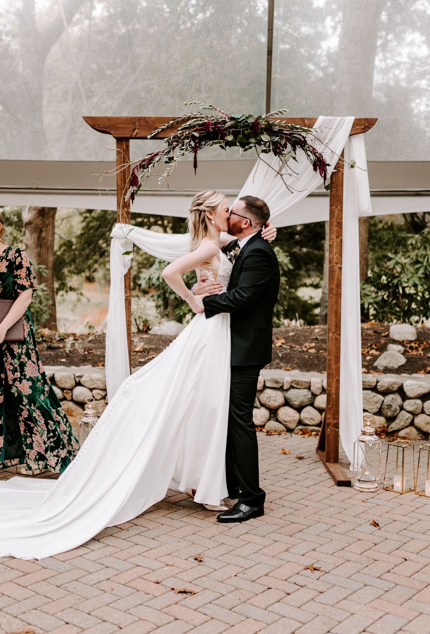 Couple sharing romantic dance moves on brick patio under wooden pergola.
