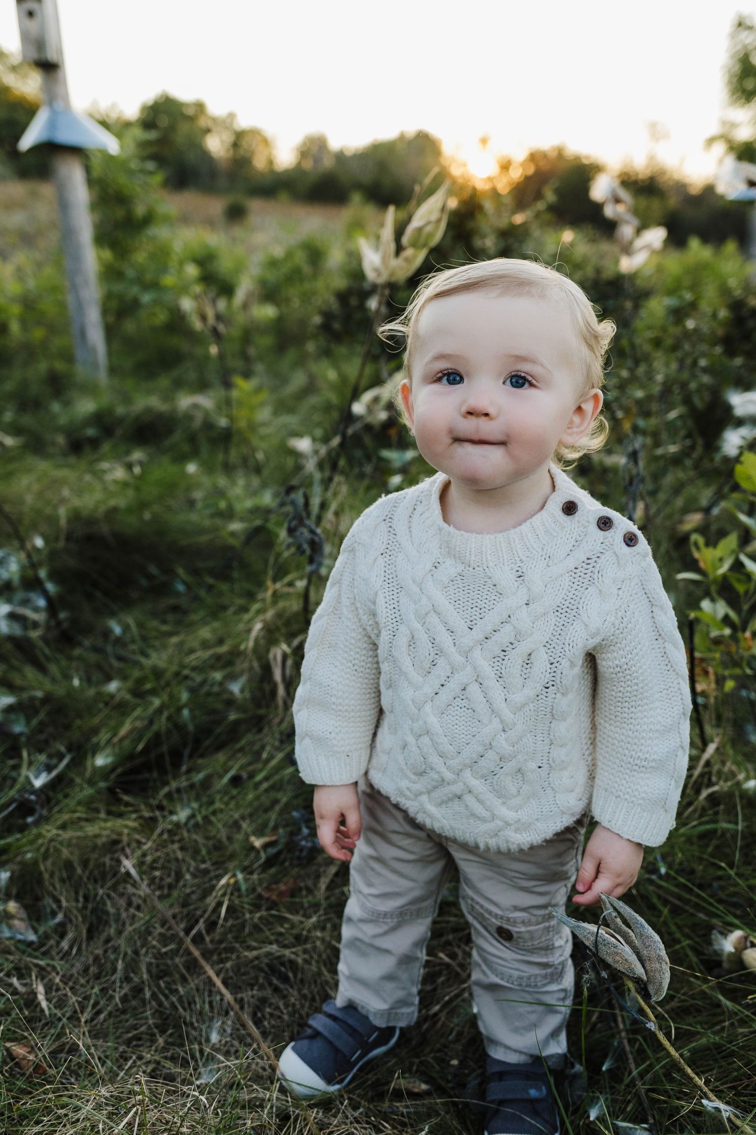 Adorable one year old boy in cute sweater gets his photos taken by photographer Pewaukee Wisconsin.